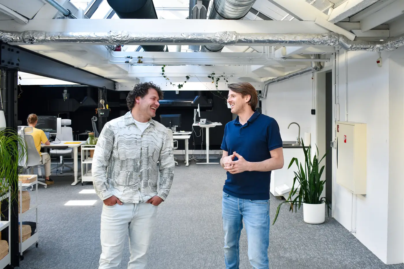 Robert en Oscar lopen in gesprek door het kantoor van Brthrs